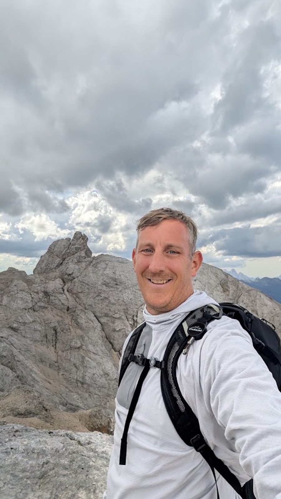 Edgar smiling on a mountain summit